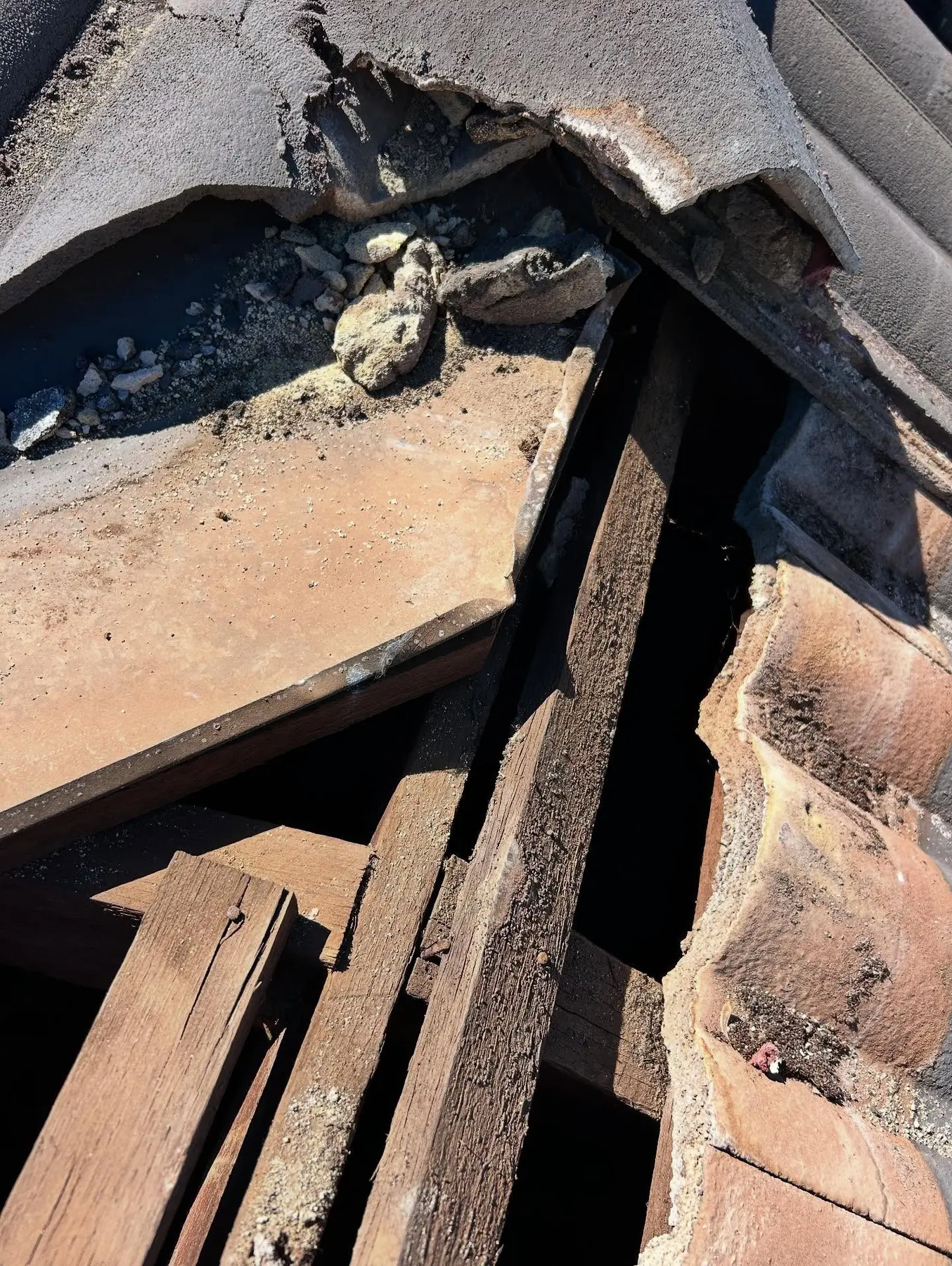 Roof tiles lifted to expose the timber roof structure during repair work